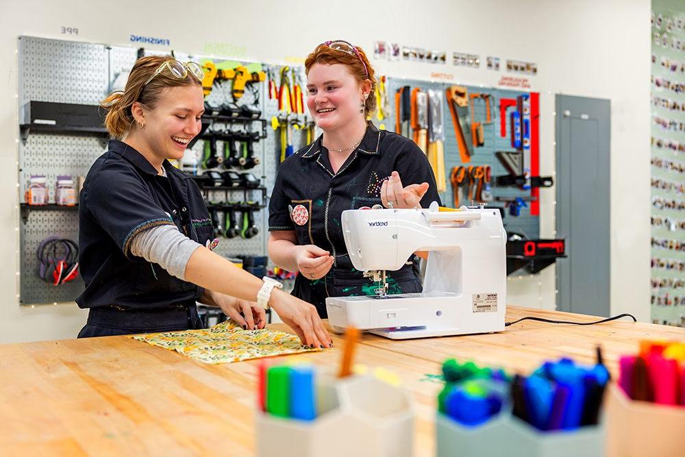 Two students using a sewing machine